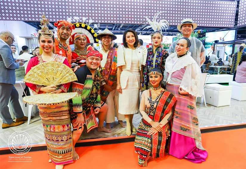 Christina Garcia Frasco with Lahing Kayumanggi performers⁤ holding traditional arts display.